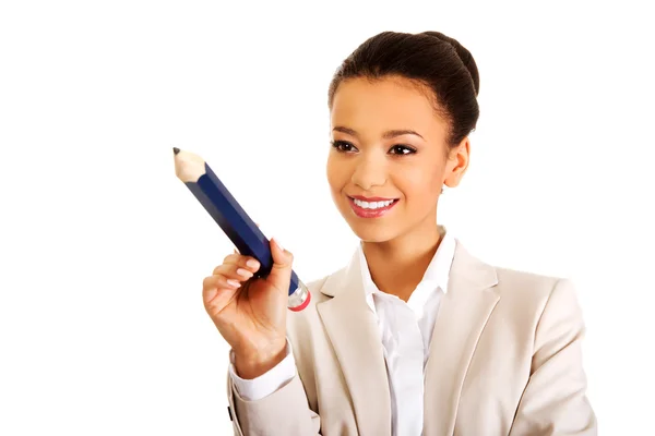 Businesswoman pointing with big pencil. — Stock Photo, Image