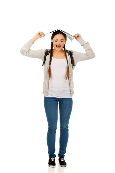 Adolescente chica con libro sobre su cabeza . —  Fotos de Stock