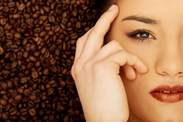 Mulher atraente deitado em grãos de café . — Fotografia de Stock