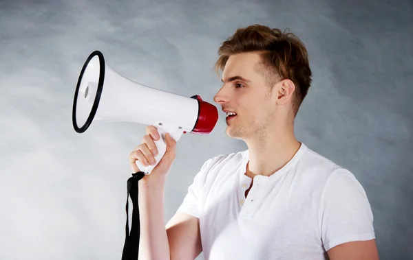 Young man shouting in megaphone. — Stock Photo, Image