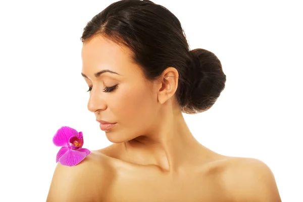 Mulher com pétala de orquídea roxa no ombro — Fotografia de Stock