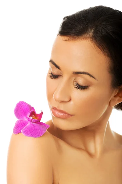 Mulher com pétalas de orquídea roxa no ombro — Fotografia de Stock