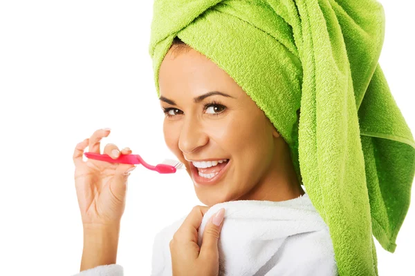 Woman in bathrobe brushing teeth — Stock Photo, Image