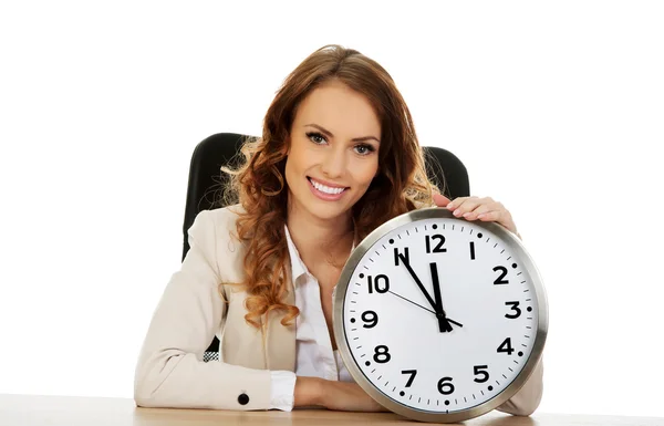 Mujer de negocios con reloj junto a un escritorio . —  Fotos de Stock