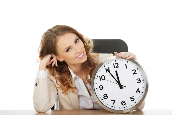Mujer de negocios con reloj junto a un escritorio . —  Fotos de Stock
