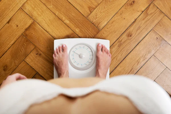 Woman standing on a scale. — Stock Photo, Image