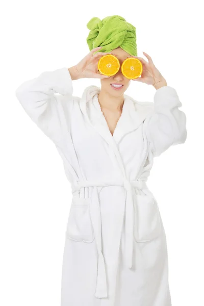 Lázně žena v županu s pomeranči. — Stock fotografie