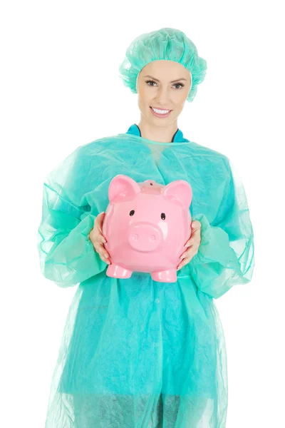 Medico femminile con salvadanaio rosa . — Foto Stock