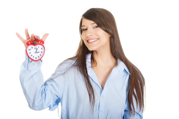 Young woman in big shirt holding alarm clock. — Stock Photo, Image