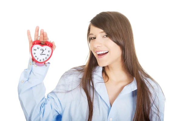 Young woman in big shirt holding alarm clock. — Stock Photo, Image