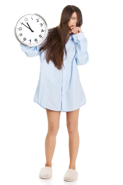 Morning woman in big shirt holding clock. — Stock Photo, Image