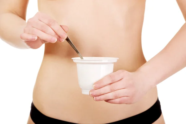 Kvinna i underkläder att äta yoghurt. — Stockfoto