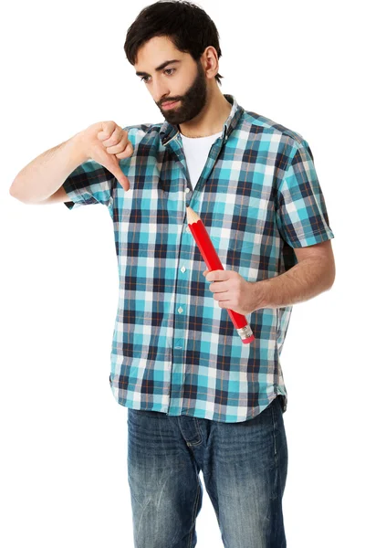 Молодой человек держит большой красный карандаш . — стоковое фото