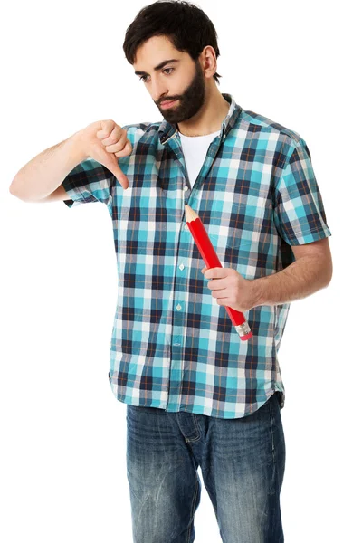 Young man holding big red pencil. — Stock Photo, Image