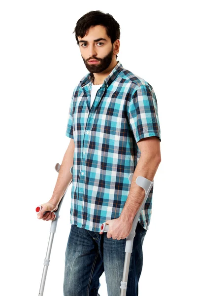 Junger behinderter Mann mit Krücken. — Stockfoto
