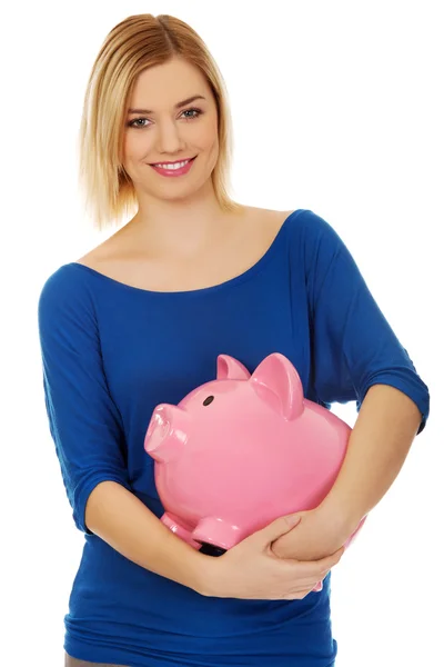 Glückliche Frau hält Sparschwein. — Stockfoto