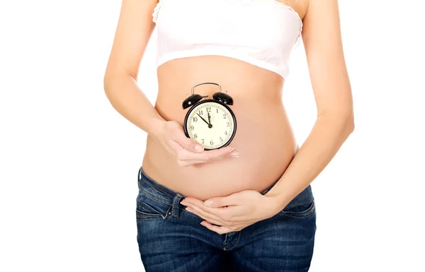 Pregnant woman with an alarm clock Stock Picture