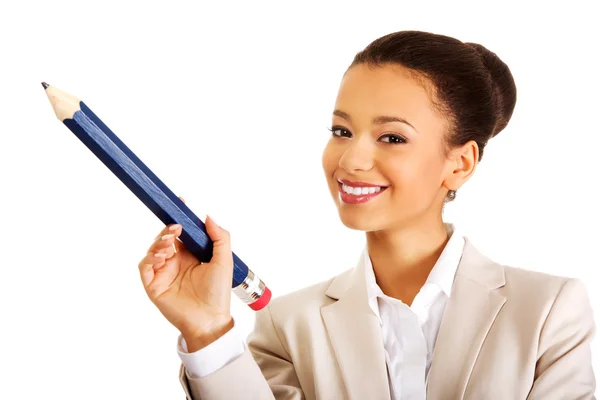 Mujer de negocios señalando hacia arriba con un lápiz grande . Fotos de stock