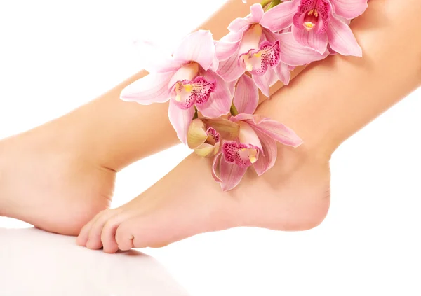De benen van de vrouw met roze bloemen. — Stockfoto