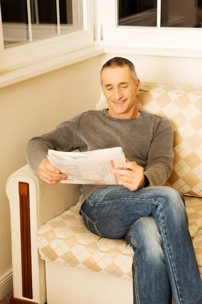 Man läser tidningen hemma — Stockfoto