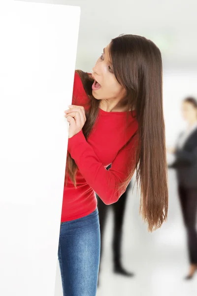 Mujer conmocionada sosteniendo banner vacío . —  Fotos de Stock