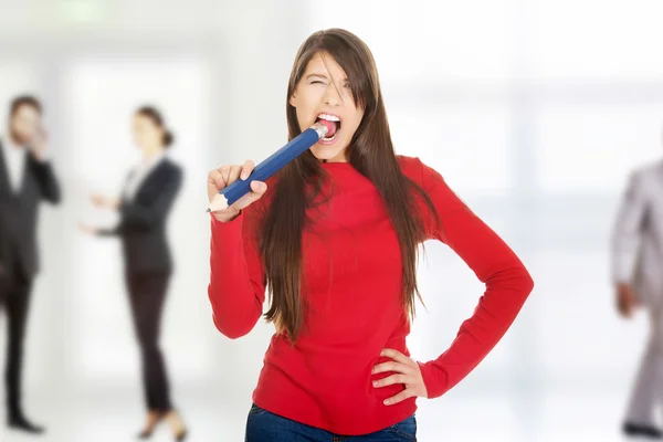 Mooie jonge vrouw bijten een potlood. — Stockfoto