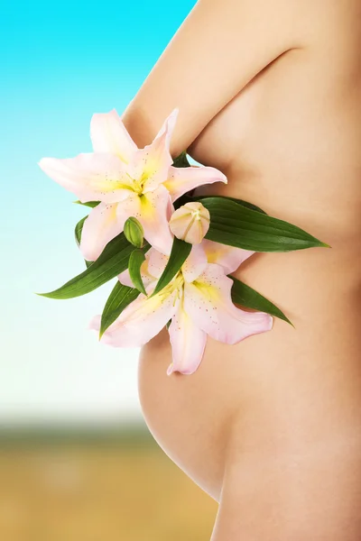 Pregnant woman holding a lily flower — Stock Photo, Image