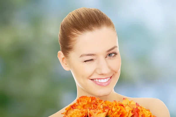 Lächelnde Frau mit frischen Rosen. — Stockfoto