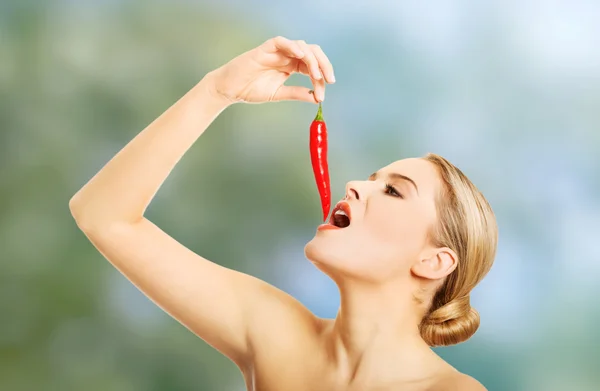 Mulher nua comendo pimenta — Fotografia de Stock