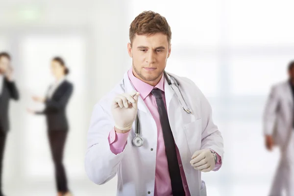 Médico varón sosteniendo una jeringa . — Foto de Stock