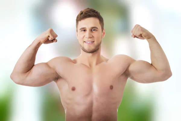 Hombre atlético joven mostrando sus músculos . — Foto de Stock