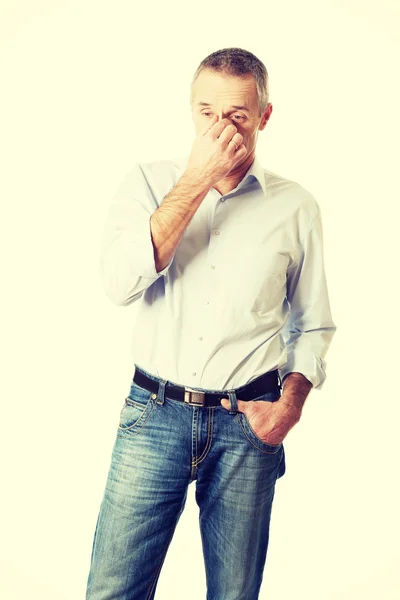 Чоловік тримає ніс через синусовий біль — стокове фото