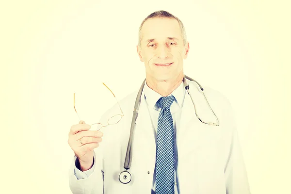 Mature male doctor holding his eyewear — Stock Photo, Image