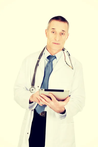 Mature male doctor using a tablet — Stock Photo, Image