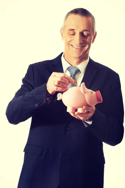 Cheerful businessman holding piggybank — Stock Photo, Image