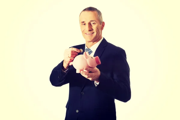 Cheerful businessman holding piggybank — Stock Photo, Image