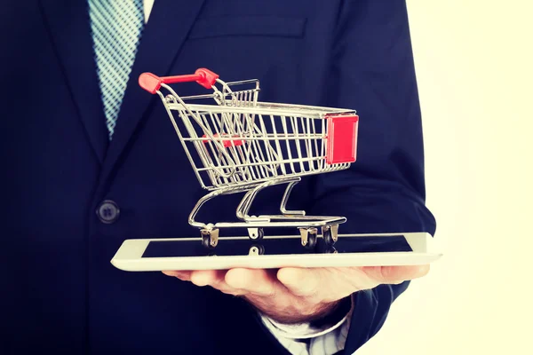 Close up man holding shopping cart on tablet — Stock Photo, Image