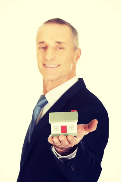 Zakenman holding house model — Stockfoto