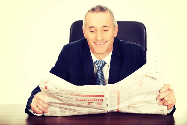 Businessman reading a newspaper in the office — Stock Photo, Image