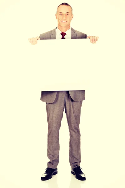 Full length businessman holding empty banner — Stock Photo, Image