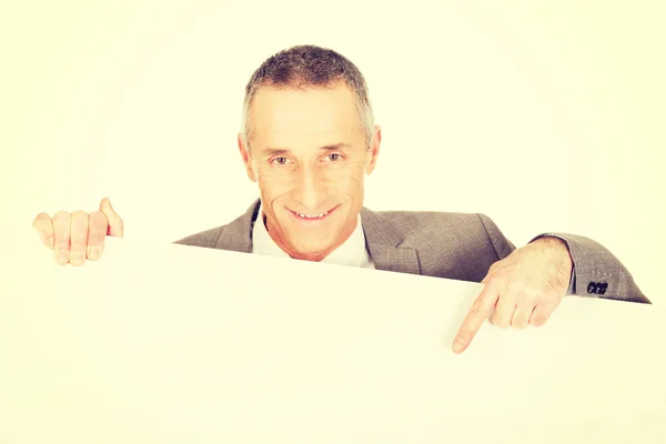 Smiling businessman pointing on empty banner — Stock Photo, Image