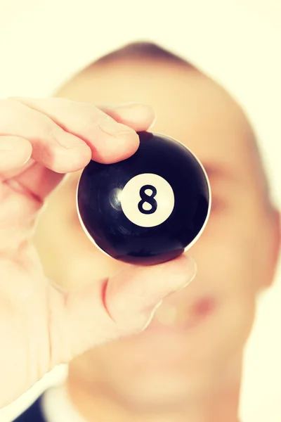 Businessman holding black billiard ball — Stock Photo, Image