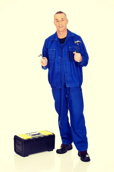 Trabajador con caja de herramientas mostrando su llave y martillo — Foto de Stock