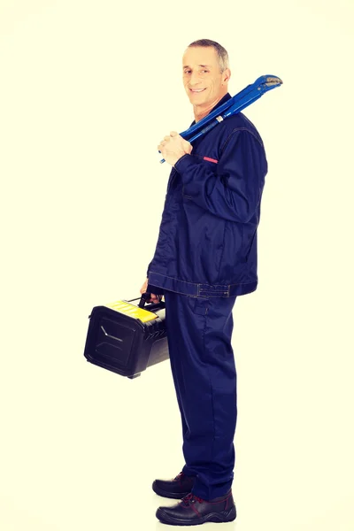 Trabalhador maduro com ferramentas saco e chave — Fotografia de Stock