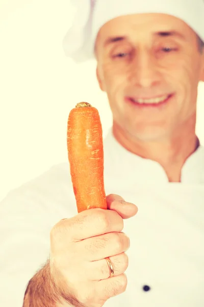 Chef masculino segurando cenoura — Fotografia de Stock