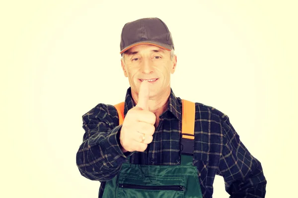 Mature gardener in uniform with thumbs up — Stock Photo, Image