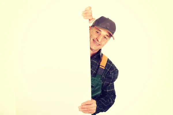 Gardener in uniform showing empty banner — Stock Photo, Image