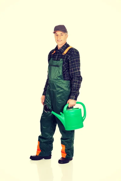 Workman holding green watering can — Stock Photo, Image