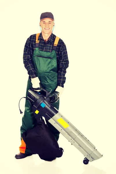 Trabajador en uniforme con un soplador de hojas — Foto de Stock