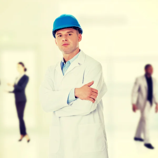 Man in lab coat and helmet — Stock Photo, Image